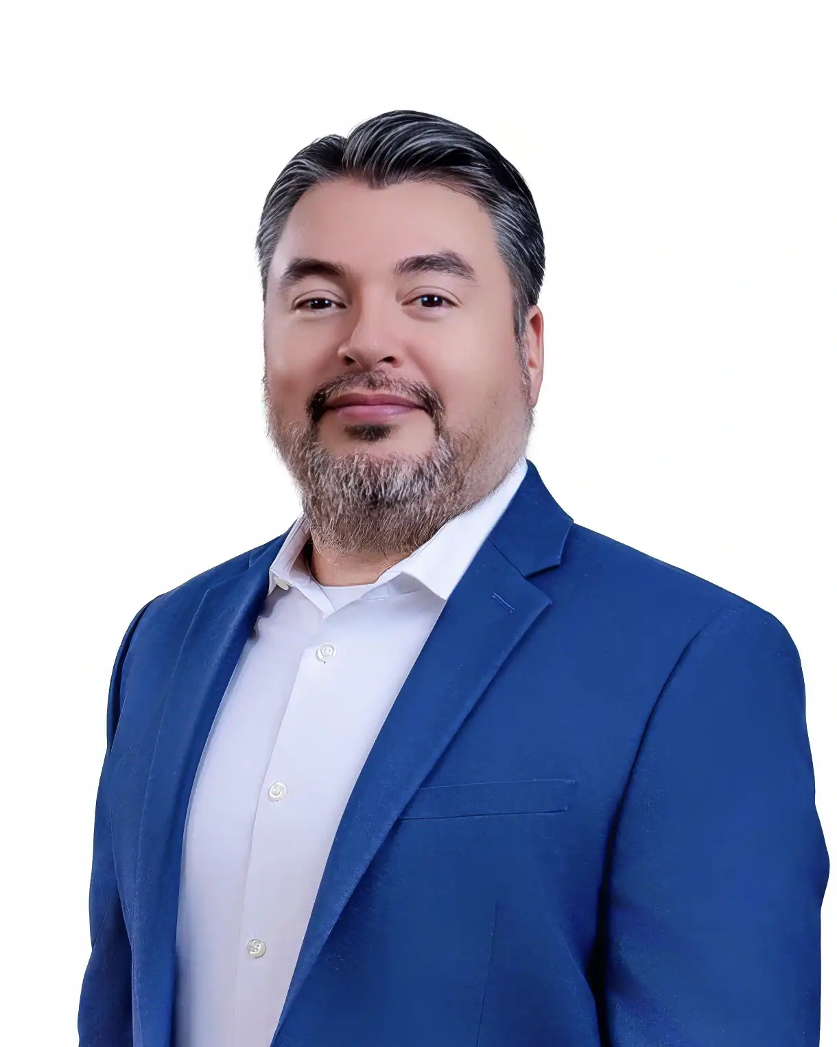 A man with dark hair and a beard, wearing a blue suit jacket and white shirt, smiles slightly while posing against a plain white background.
